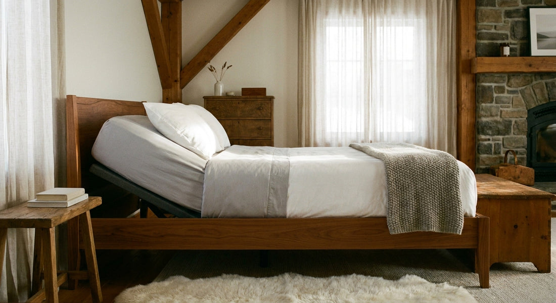 A sunlit bedroom featuring a neatly dressed adjustable electric bed with perfectly fitted custom grey and white sheets, bathed in soft morning light.